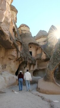 Couple walks hand in hand through the stunning fairy chimneys of Cappadocia, Turkey. Pasabag Monks Valley 