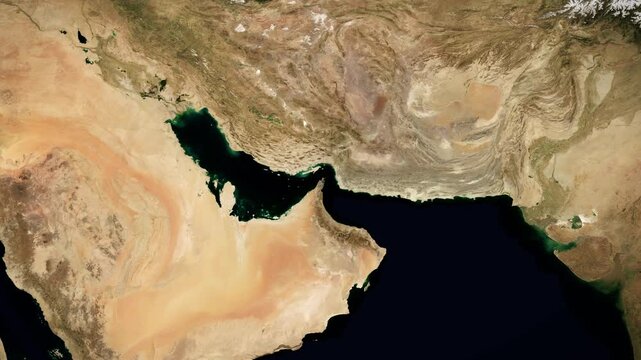 Camera zooms slowly into the Strait of Hormuz on a satellite map. Map showing the location of Iranian blockade of the important oil and cargo shipping route. Iran War