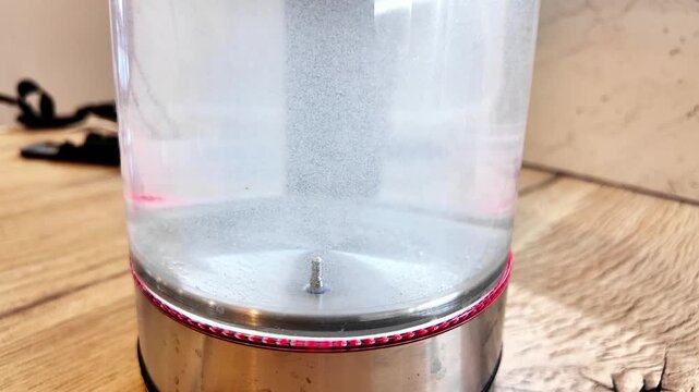 Steady Microbubble Activation Inside Glass Kettle With Subtle Central Column And Glowing Led Rim, Quiet Kitchen Counter Study Capturing Early Stage Of Liquid Motion And Base Detail