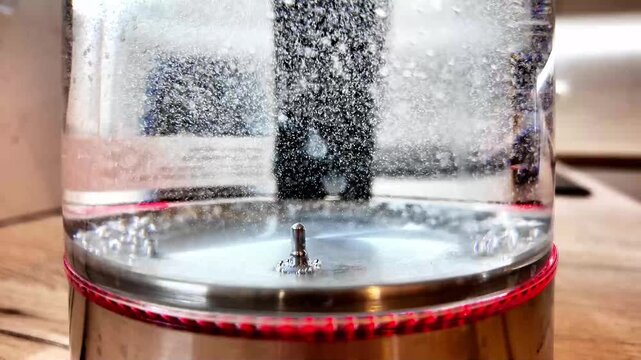 Intense Bubble Curtain Rising Inside Glass Vessel, Dramatic Kitchen Lighting Highlights Frothy Specks And Swirling Center Column, Scientific Experiment Atmosphere With Textured Wood Surface