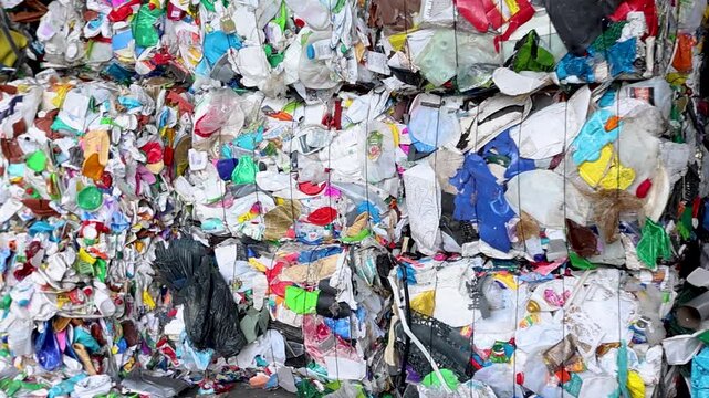 A stream of mixed waste moves across a vibrating feeder inside a recycling plant. 