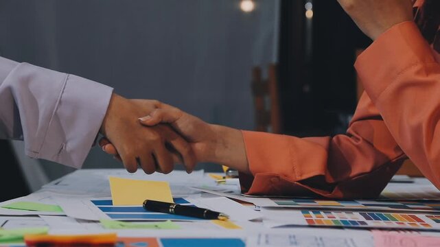 Asian women working together as web designers in an office, pointing at whiteboard with uxui mobile app wireframe