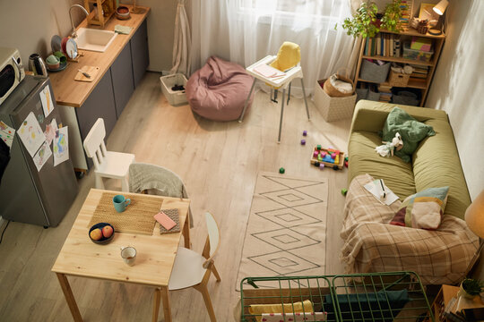 High angle view of small family apartment showing child care items, toys, simple kitchen, cramped living area, illustrating low income household. Useful for poverty, housing hardship, social support