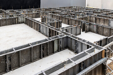 住宅密集地での基礎工事 鋼製型枠の設置完了とアンカーボルト 建築現場の全景 © Buppy