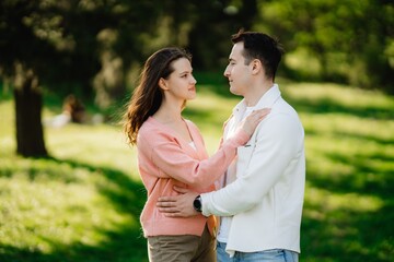 Obraz premium Couple enjoying a romantic moment in a sunny park during early spring