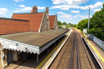 Obraz premium Battle Railway Station Platform and Tracks in Battle, East Sussex, England, UK under Blue Sky