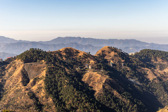 lush green hills and pine forest valley with small village scenic mountain landscape view