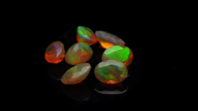 Polished Fire Opals with Vibrant Orange and Green Play of Color on Black Background, Macro Jewelry Shot