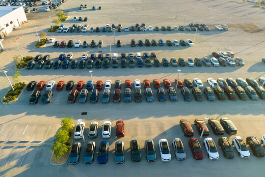 Aerial view of dealership parking lot with many brand new cars for sale. Development of american automotive industry concept