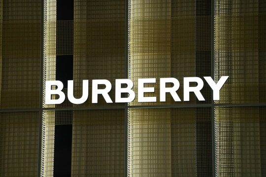 Burberry luxury brand signage on an illuminated check pattern wall.