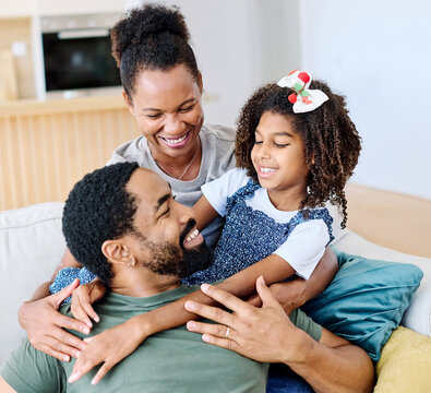 Portrait of a happy black family mother father and daughter at home on couch