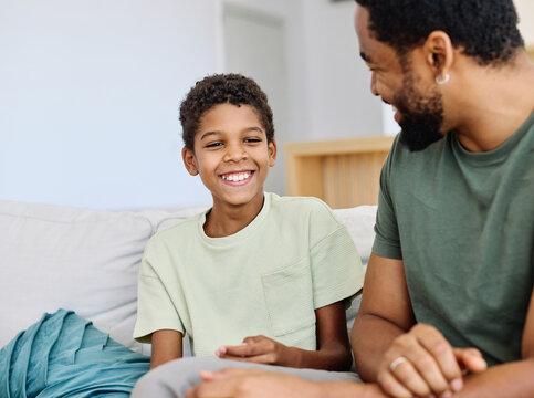 Portrait of a happy teenage boy son talking to his father at home. Sharing secrets and having fun, support and parenthood concept