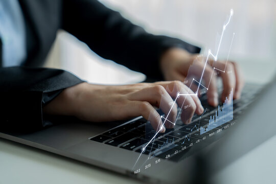 A business professional engaged in data analysis on a laptop, showcasing digital graphs to reflect market trends and financial insights in a contemporary office setting. Scalp