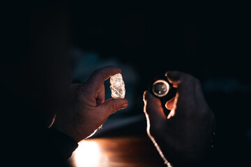 Inspection of raw diamond by caucasian male in dim lighting © Parilov