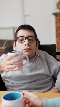 Joyful morning moments as a loving mother and her son with a physical condition share coffee and conversation, fostering a strong family bond