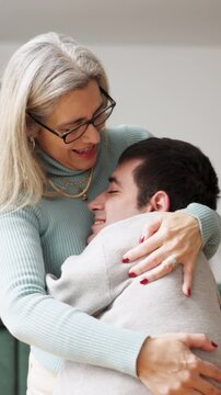 Loving mature mother embracing her adult son with a physical condition. Heartwarming moment of family care, support, and unbreakable bond