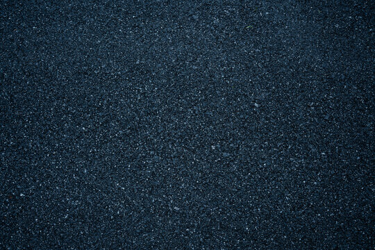 Dark asphalt road texture with rough surface and detailed grain, ideal for background pattern