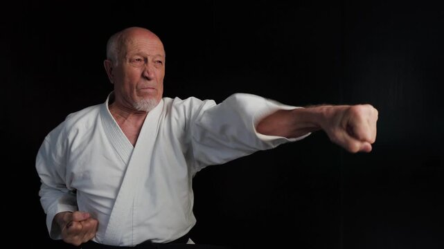 An old male athlete throws punches against a background of flashing red and green lights
