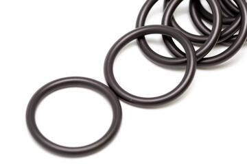 Fototapeta premium Rubber O-rings sealing industrial components, used for leak prevention in plumbing and machinery, arranged on a clean white background—ideal reference for designers working on engineering, maintenance