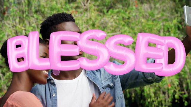Couple holding phone starting social selfie leaning hand on chest BLESSED text appearing over faces