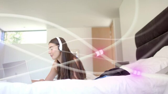 Woman beginning by typing on laptop on bed, studying remotely, purple streaks sweeping across frame