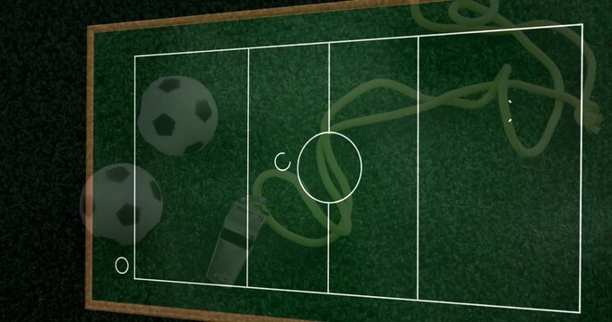 Displaying green turf board with pitch lines on table, soccer balls, whistle, yellow cord, markers