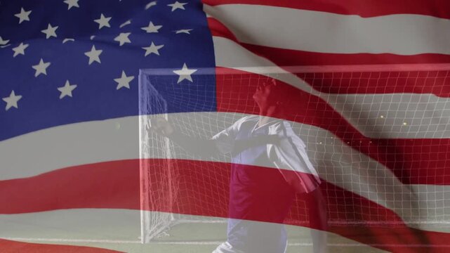 At start athlete walking past goal turning raising arm sweeping leg US flag drifting showing pride