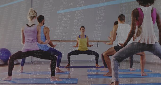 Leading trainer guiding squat in studio in yellow-tank dark-leggings with blue mats code overlay