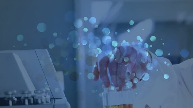 Hand entering with yellow vial, technician rotating and placing vials into analyzer to load samples