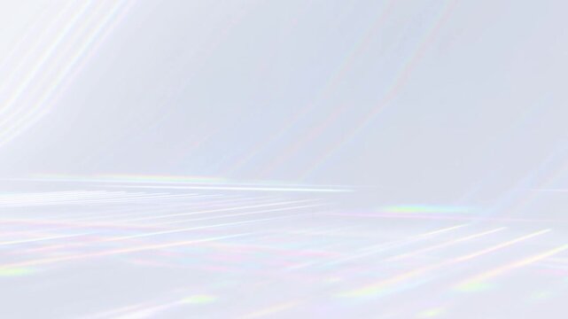 Slow pan of iridescent light reflections drifting across white studio floor with soft rainbow beams and subtle shimmering highlights in minimal backdrop