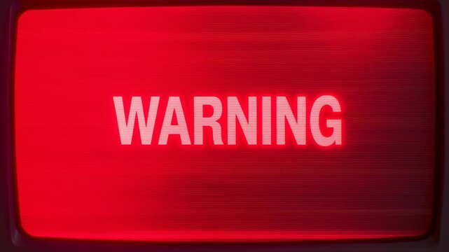 Panning shot across red warning message displayed on three monitors in control room console with pulsing alert lights and high contrast screens
