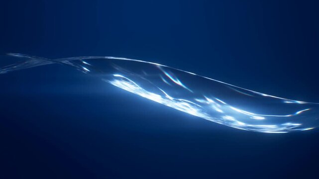 Slow tracking pan of liquid ribbon flowing and shimmering across dark blue seamless background in studio abstract minimal setting