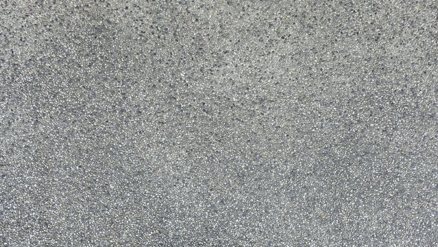 Gray gravel concrete floor, road surface, walkway surface, small gravel road surface, texture, and background. Gray exposed aggregate concrete texture with fine pebbles.