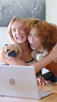 Vertical video: Arriving right friend with headset greeting and hugging woman at table with laptop