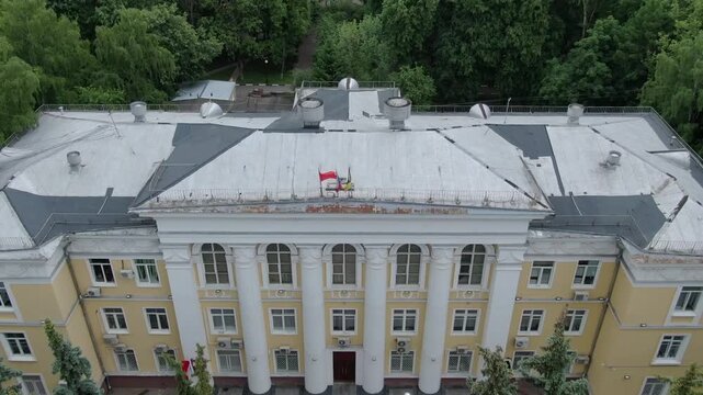 Drone flying backward above administration building roof