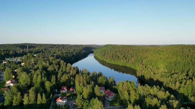 Beautiful aerial perspective of Kaukaj&auml;rvi in Kangasala, Finland during a clear summer day. The vibrant greens of the forest meet the deep blue lake under bright sunlight, creating a peaceful Nordic