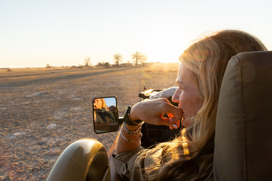 woman using smart phone to photograph baobab tree, Makgadikgadi National Park, Botswana, Africa