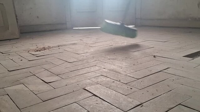Old wooden parquet floor cleaning motion video footage showing dust being swept