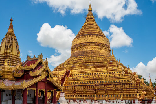 Golden details of Shwezigon Pagoda with minor temples and red pavilions