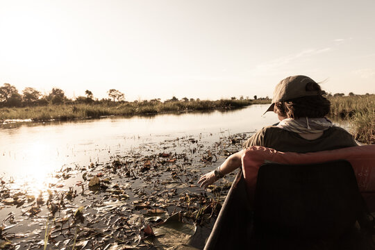 child in traditional makoro boat, navigating the Okavango Delta, Botswana, Africa