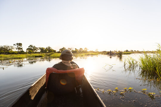 child in traditional makoro boat, navigating the Okavango Delta, Botswana, Africa