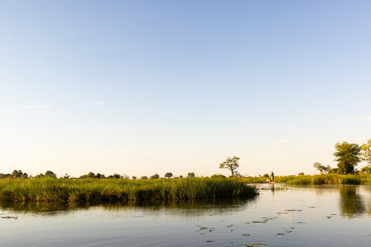 child in traditional makoro boat, navigating the Okavango Delta, Botswana, Africa