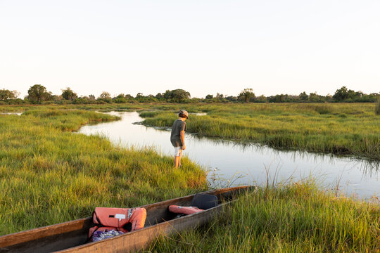 child in traditional makoro boat, navigating the Okavango Delta, Botswana, Africa