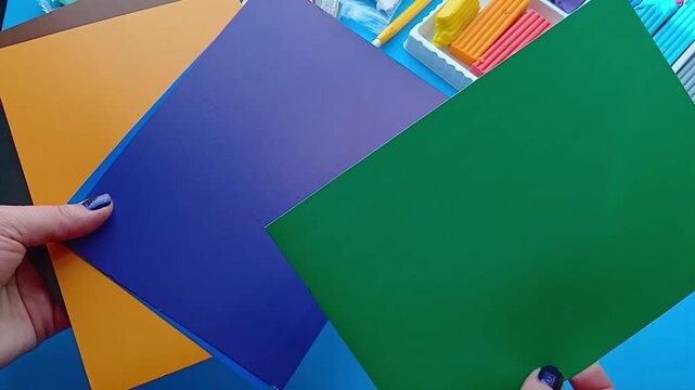 Hands are sorting through colored paper - preparation for the creative process
