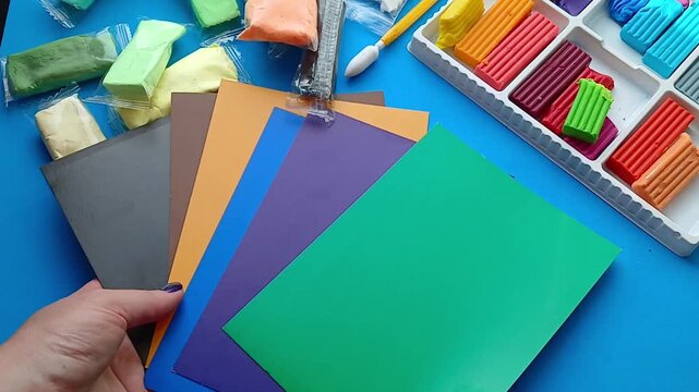 Hands are sorting through colored paper - preparation for the creative process
