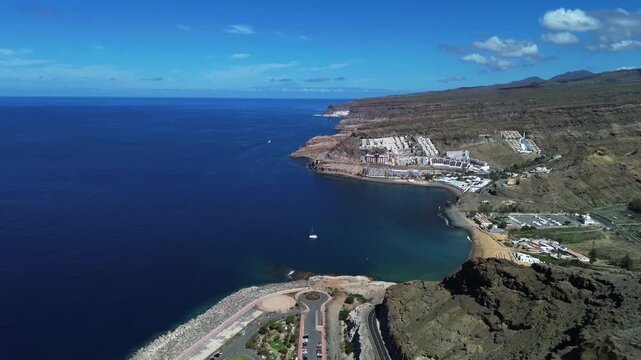 Aerial panoramic view of Gran Canaria rugged coastline, Atlantic Ocean and coastal resorts under a blue sky