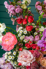 Obraz premium Vibrant flower bouquet display. A colorful arrangement of various flowers is set against a green background.