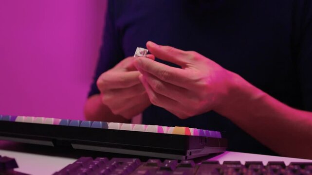 Keyboard modding scene. Closeup of key replacement in vibrant studio setting. Dynamic view of mechanical key modding process illuminated by bright pink studio lighting