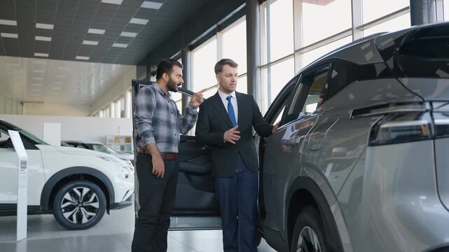 Car salesman showing new automobile to a Indian customer