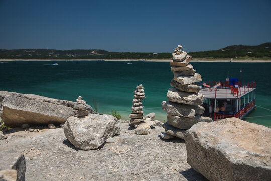 Stacks of Balanced Rocks  with Lake 
 behind them for  Good  Luck during party Barge Boat in lake Travis Austin Texas